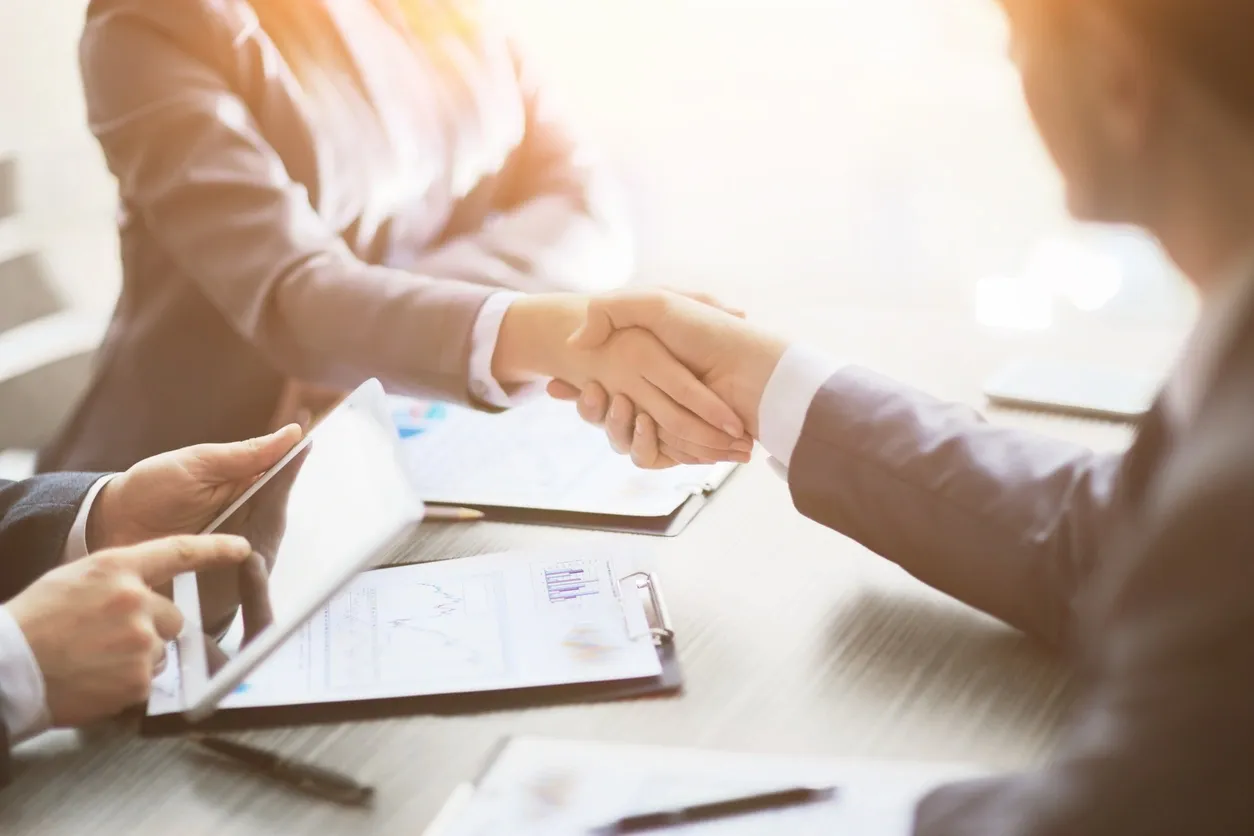 Two people shaking hands during a business meeting.